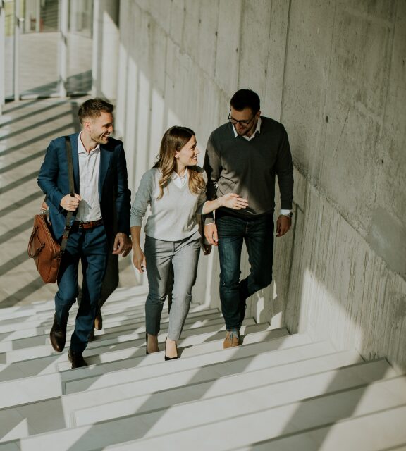 Mitarbeiter-laufen-fröhlich-die-Treffe-im-Office-hoch-und-tauschen-sich-dabei-aus-Kienbaum-576-640